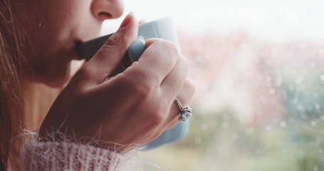 Young Woman Enjoying her morning coffee or tea, Looking Out the