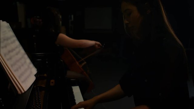 Two women playing a violin and piano