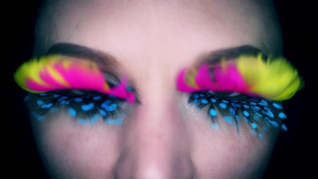 4k Colourful Woman Eyes Close-up with Feathers Eyelashes Flapping