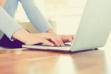 Fototapeta premium Woman working on a laptop in a bright room