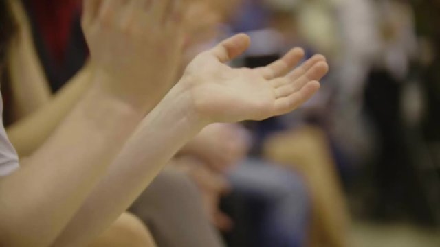 People applaud - close-up of clapping hands of sitting people on dancing event