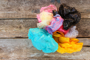 Different plastic bags on old wooden background. Top view. 