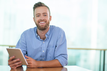 Happy Man Sitting at Cafe Table and Using Tablet