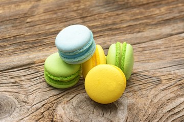 Different kinds of macaroons on wooden background