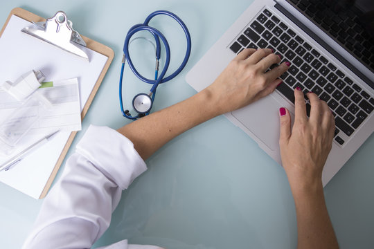 Hands of a female doctor working on laptop