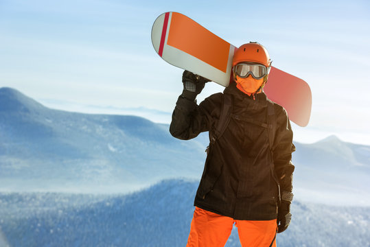 Snowboarder snowboard portrait mountain top orange