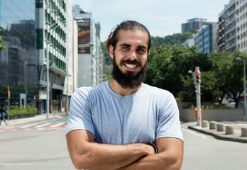 Sympathischer Mann mit Vollbart im grauen Shirt in der Stadt