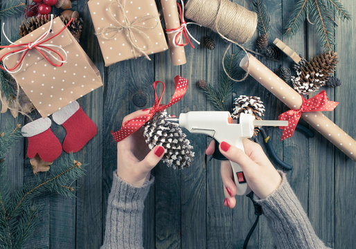 Christmas background. Top view of woman's hands gluing ribbon to