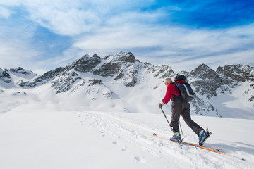 Fototapeta na wymiar Elderly man sporting fit skis uphill climbing