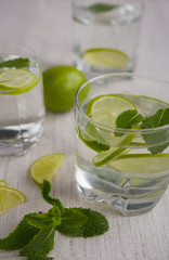 Refreshing drink with lime, mint and cranberries on a light background