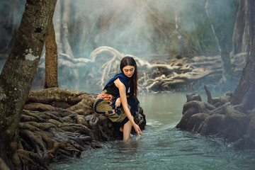 Asian woman wearing traditional thai take a baht on during sunset,vintage style