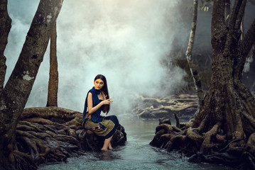 Fototapeta premium Asian woman wearing traditional thai take a baht on during sunset at river,vintage style,Beutiful woman take a baht in river,woman wearing thai culture