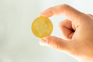 Golden Bitcoin in a man's hand
