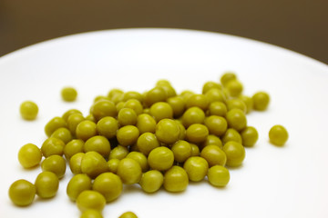 green peas on a white plate with bokeh effect