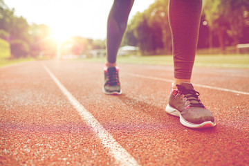 close up of woman feet running on track from back