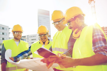 group of builders with tablet pc and blueprint