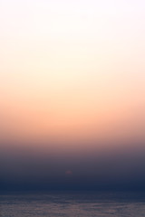 Tranquil and serene sunset at the sea or ocean. Colorful gradient