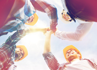 close up of builders in hardhats making high five