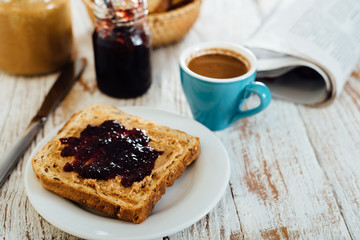 Homemade peanut butter and jelly sandwich on wooden background