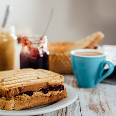 Homemade peanut butter and jelly sandwich on wooden background
