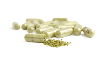 green capsule pills on white background