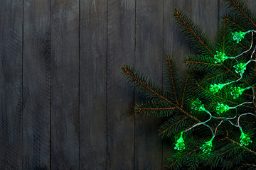 Christmas lights on a wooden background with free space.