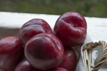 Several red plums in the basket