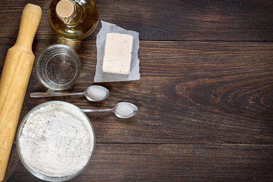 Baking ingredients and kitchen utensils for pizza dough.