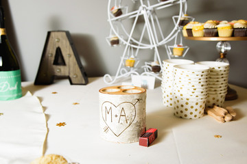 Candleholder with lettering 'M+A' stands on white candy bar