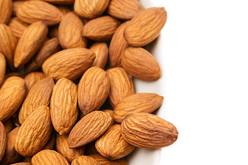 Nuts border of almonds on white background. Pile of selected almond close-up. Isolated.  For vegetarians.