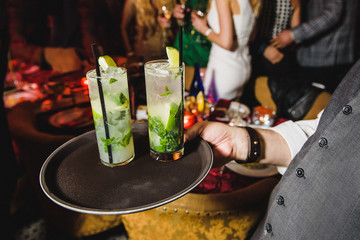 Glasses with mochito stand on black tray