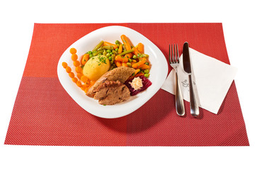 Traditional Romanian calf boiled meat with boiled vegetables on white plate and red place mat, isolated on white background