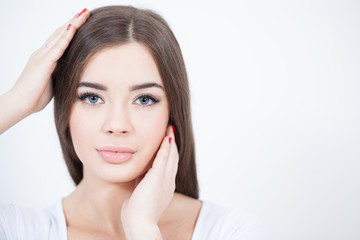 Fototapeta premium Beautiful Young Woman with Fresh Clean Skin touch own face. Red lips, red lipstick. Cosmetology, beauty and spa. 