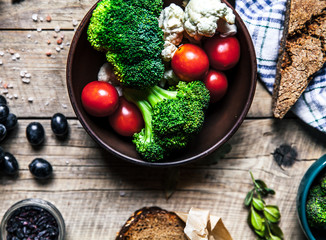 Fresh bread with vegetables and spices on wooden background. women's hands. Food, empty space for text.