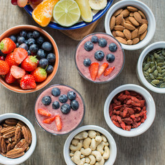 Coconut milk chia pudding with berry smoothie with berries on top, served with fruits and nuts, selective focus, top view, square