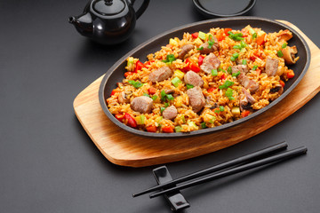 Japanese cuisine. Rice with pork over black background.