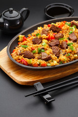 Japanese cuisine. Rice with veal over black background.