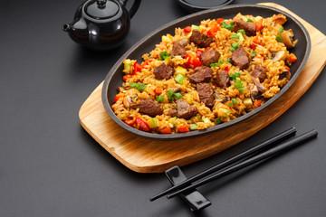 Japanese cuisine. Rice with veal over black background.