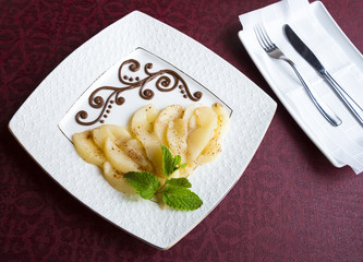 Pieces of caramelized pears on a white serving dish