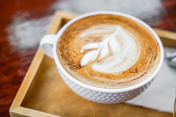Latte Coffee art on the wooden table .
