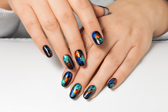 Women's hands with an abstract pattern on the nails.