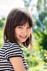 Fototapeta premium Portrait of a beautiful and happy girl outdoors in summer