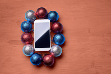 The wooden table with a phone and Christmas decorations.