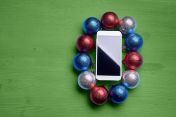 The wooden table with a phone and Christmas decorations.