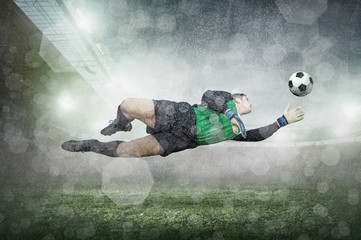 Soccer player with ball in action at stadium under rain.