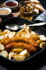 fried pork sausages with potatoes in frying pan for lunch