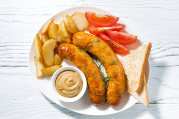 fried sausages with potatoes and mustard, top view
