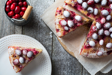 Homemade cranberry pie with walnuts, berries and powdered sugar. Top view. Space for text. Rustic style. Selective focus.