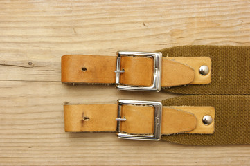 leather strap with a buckle on a wooden board