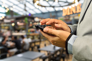 Man using Smartphone or Cellphone in café or Restaurant
